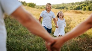A couple of people holding hands in a field
